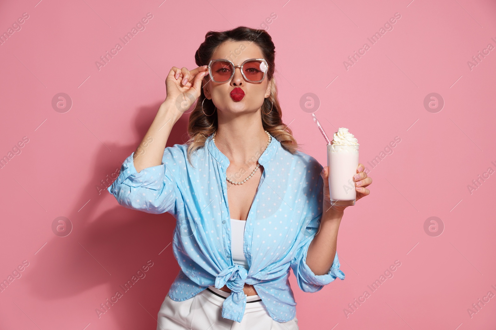 Photo of Attractive pin-up woman with milk shake on pink background