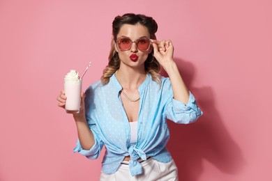 Photo of Attractive pin-up woman with milk shake on pink background