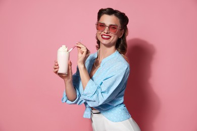 Photo of Happy pin-up woman with milk shake on pink background