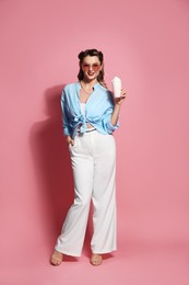 Photo of Happy pin-up woman with milk shake on pink background