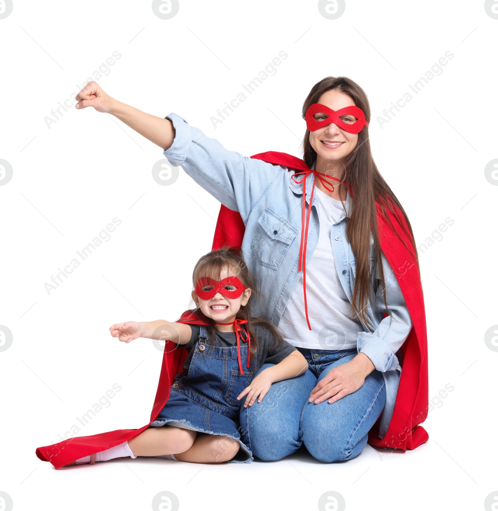 Photo of Mother and her cute little daughter wearing superhero costumes on white background