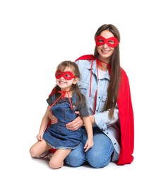 Photo of Mother and her cute little daughter wearing superhero costumes on white background