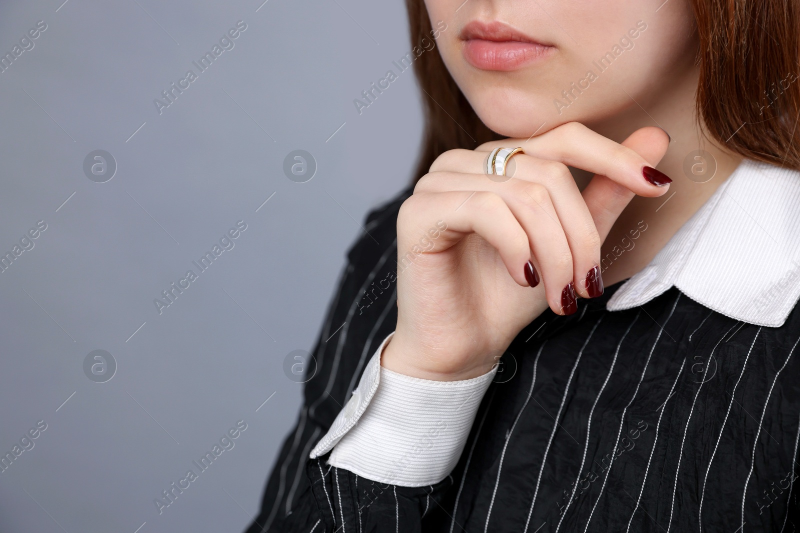 Photo of Teenage girl wearing stylish ring on grey background, closeup. Space for text