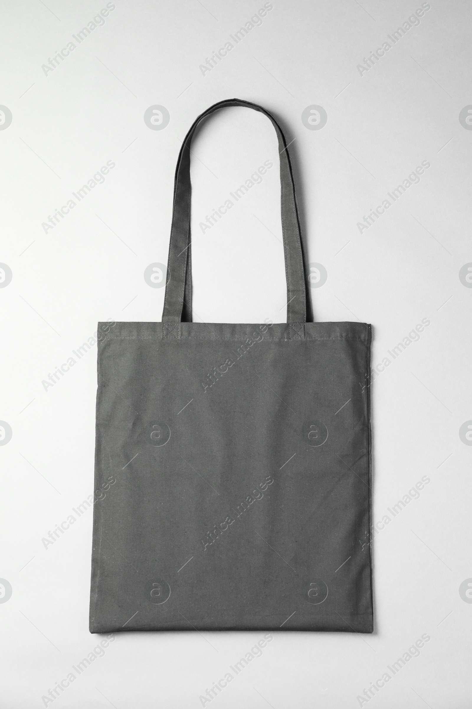 Photo of One shopping bag on grey background, top view. Mockup for design