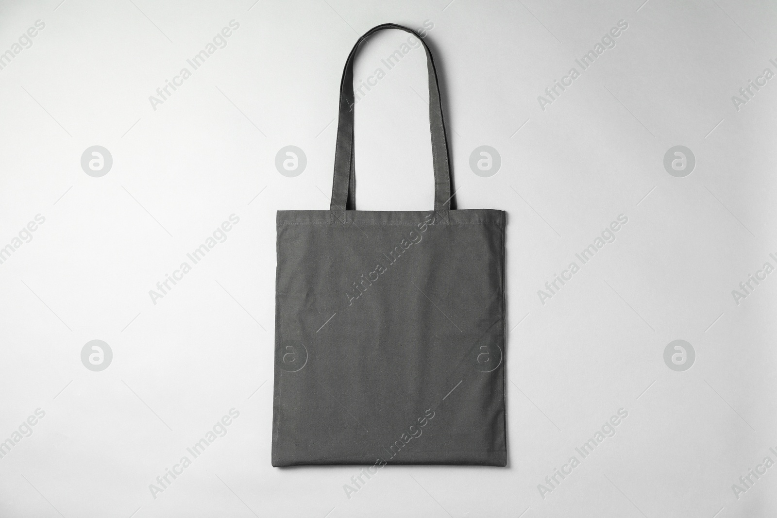 Photo of One shopping bag on grey background, top view. Mockup for design