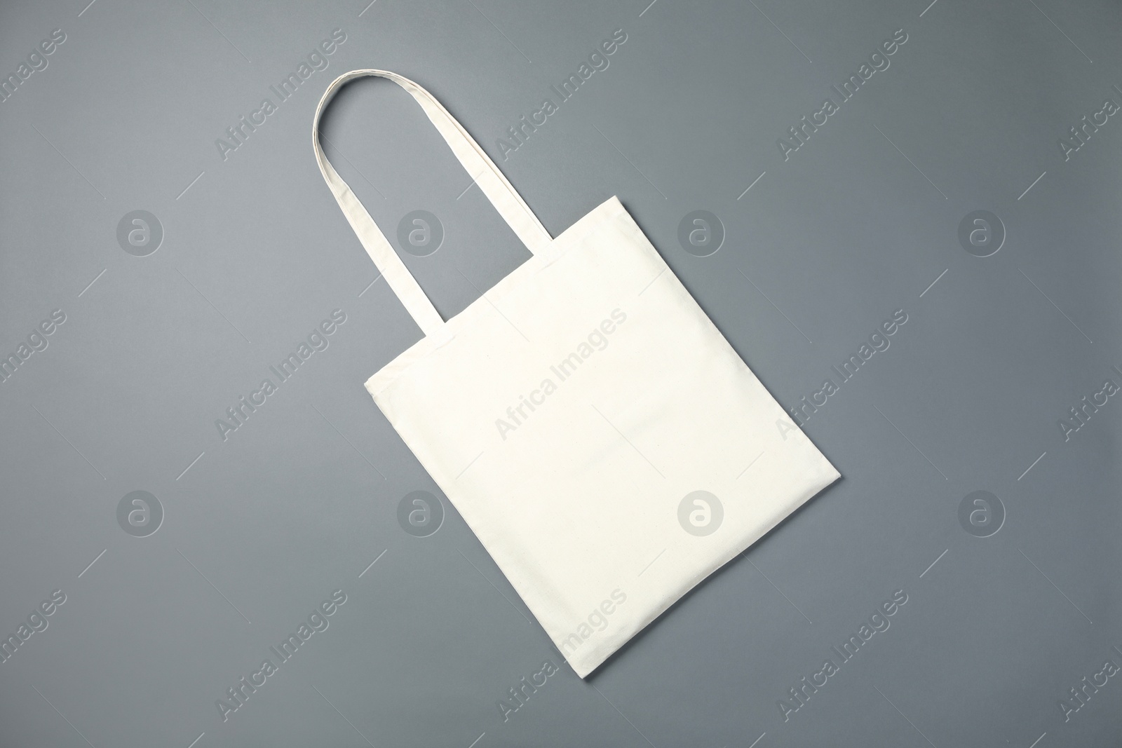 Photo of One shopping bag on grey background, top view. Mockup for design