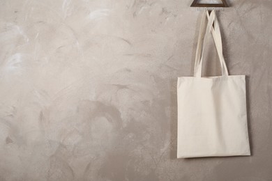 Photo of Eco bag hanging on grey wall. Mockup for design