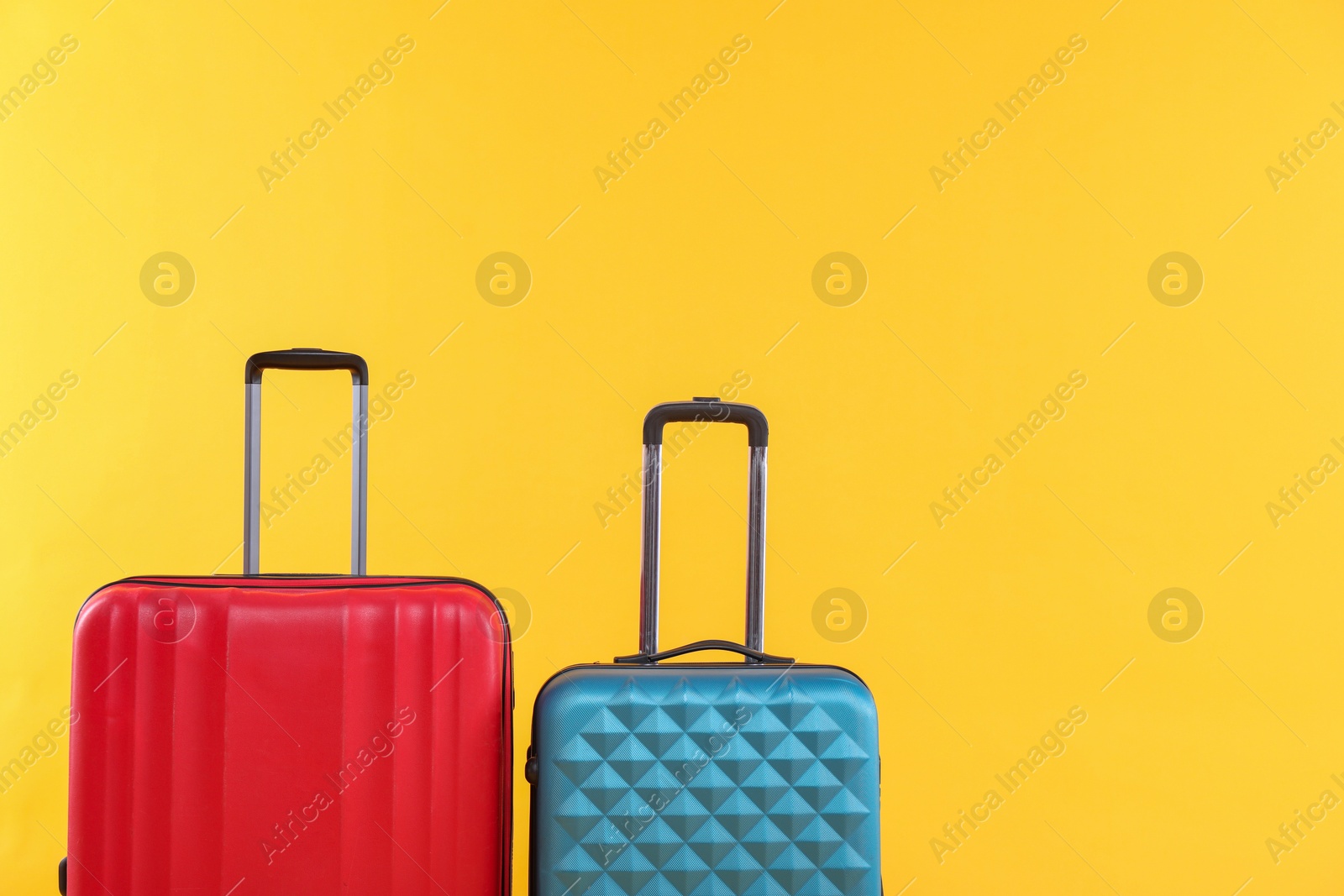 Photo of Travel abroad. Packed suitcases on yellow background, space for text