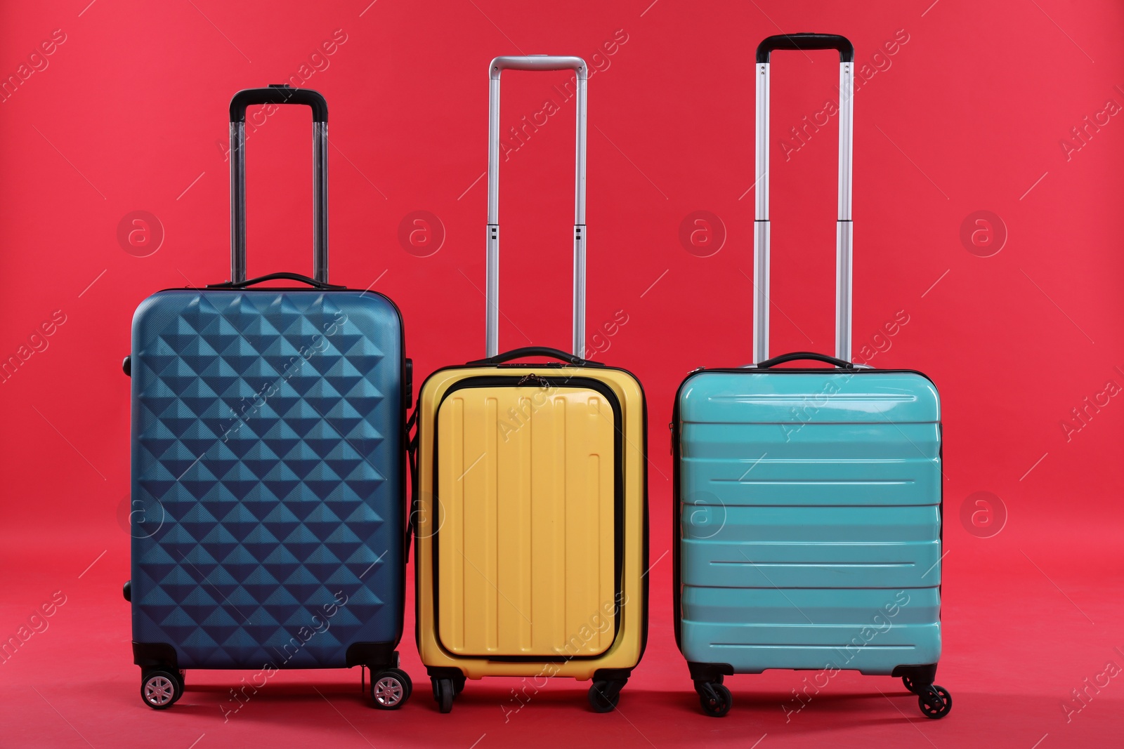 Photo of Different packed suitcases on red background. Travel luggage