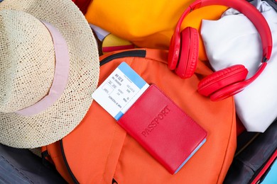 Photo of Different clothes, backpack, passport and ticket as background, closeup. Travel luggage