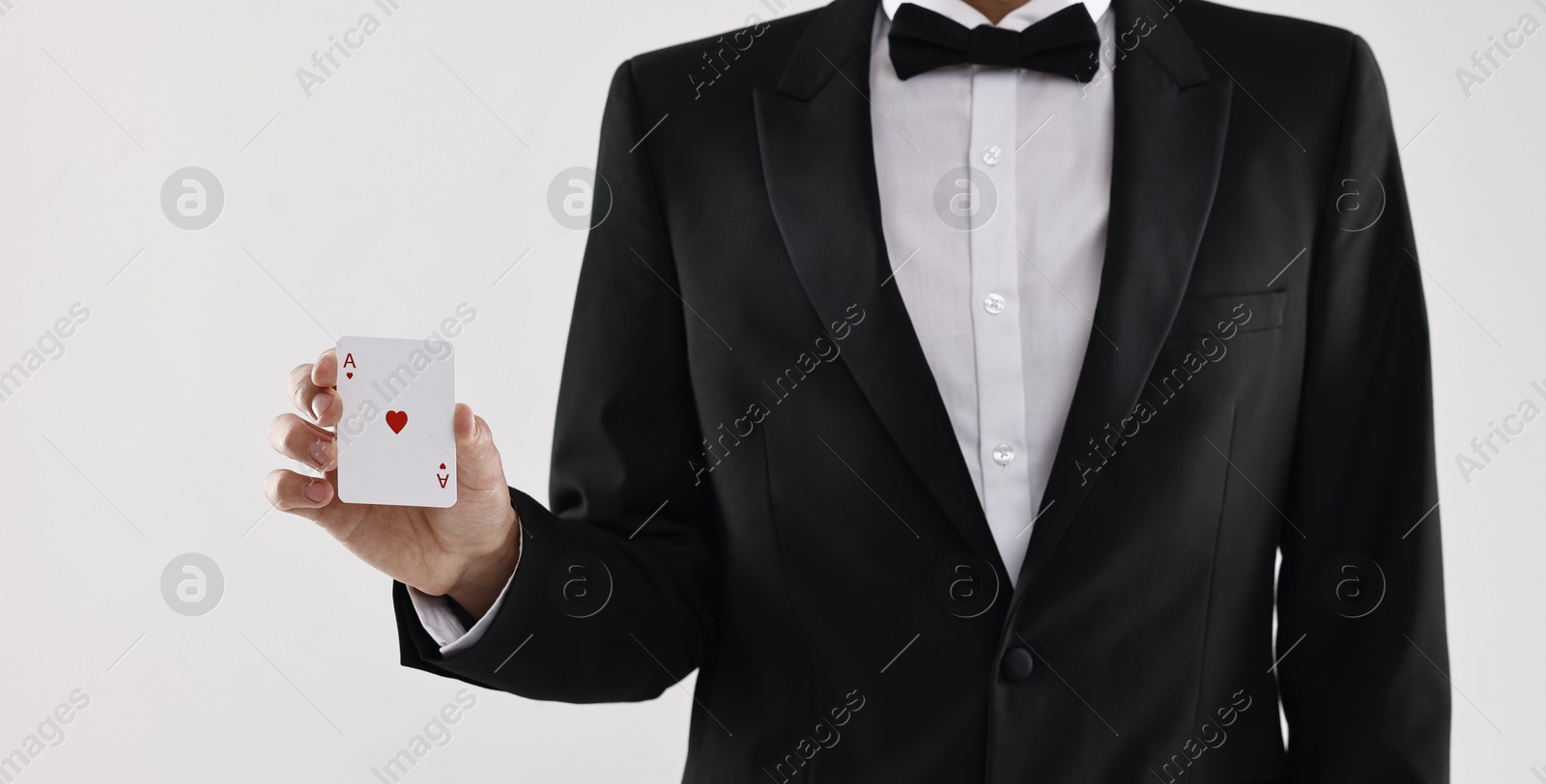 Photo of Illusionist showing playing card on white background, closeup