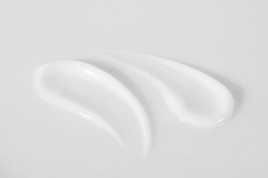 Photo of Smears of cosmetic product on white background, closeup