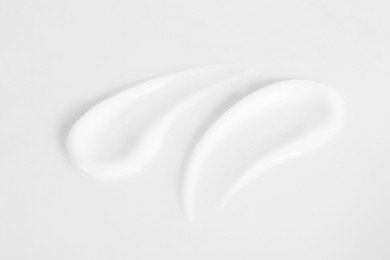 Photo of Smears of cosmetic product on white background, closeup