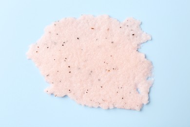 Photo of Sample of body scrub on light blue background, top view. Skin care