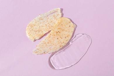 Photo of Samples of cosmetic products on light violet background, top view. Skin care