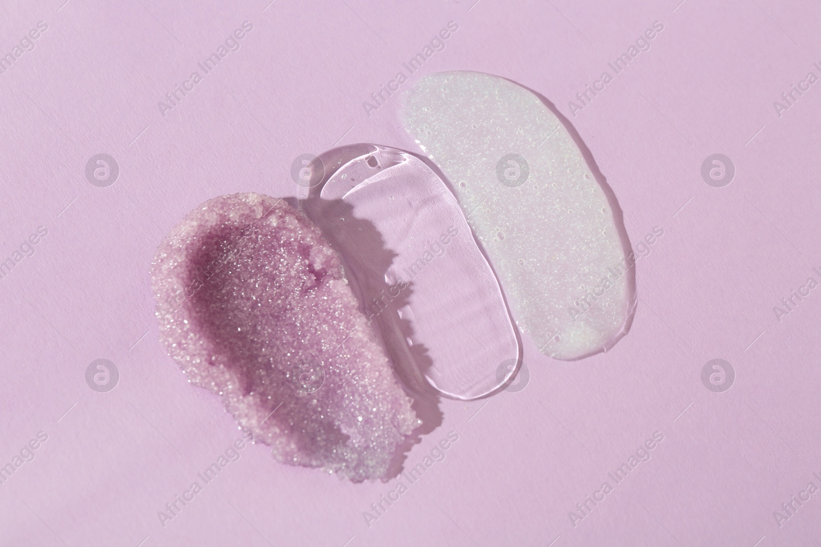 Photo of Samples of cosmetic products on light violet background, top view. Skin care