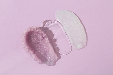 Photo of Samples of cosmetic products on light violet background, top view. Skin care