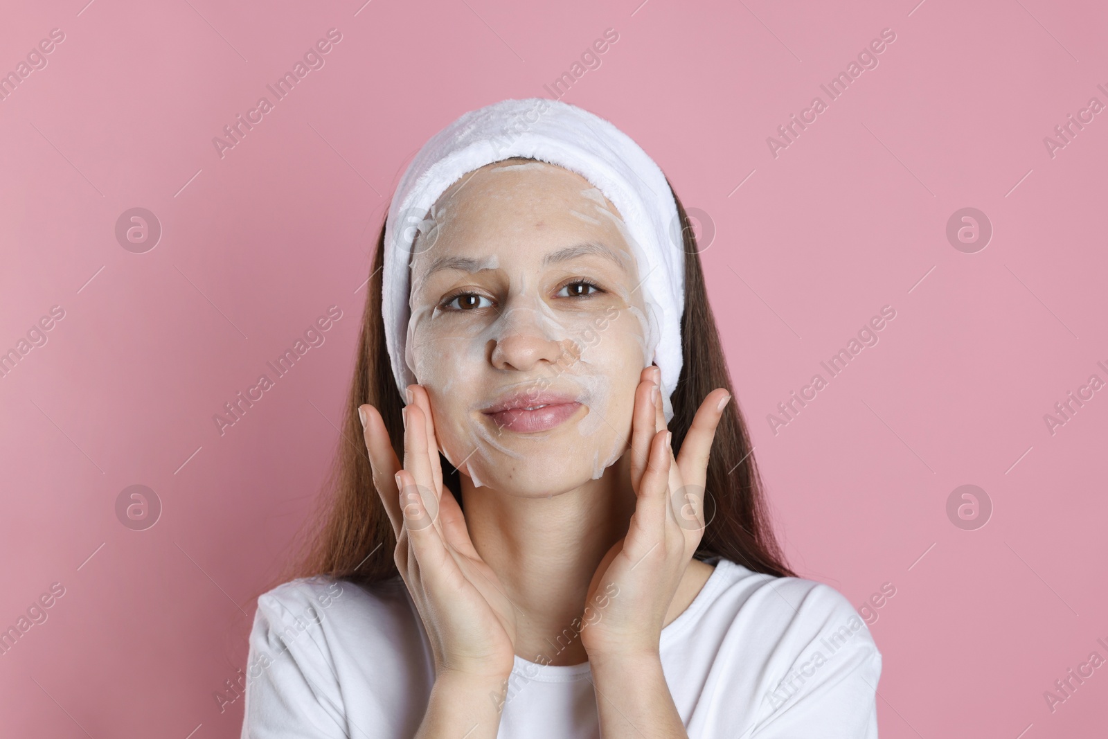 Photo of Teenage girl with sheet facial mask on pink background. Acne treatment