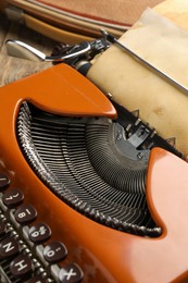 Photo of Vintage typewriter with sheet of parchment paper on table, closeup
