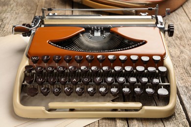Photo of Vintage typewriter and sheets of paper on wooden table, closeup