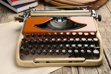 Photo of Vintage typewriter and sheets of paper on wooden table, closeup