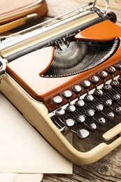 Photo of Vintage typewriter and sheets of paper on wooden table, closeup