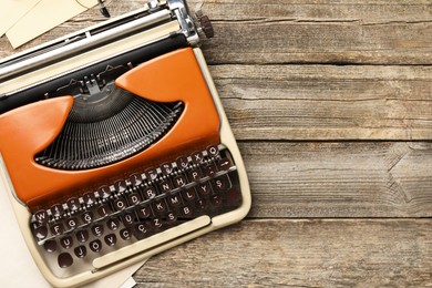 Photo of Vintage typewriter on wooden table, top view. Space for text