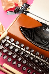 Photo of Vintage typewriter with sheet of paper on pink background, closeup