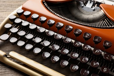 Photo of Vintage typewriter on wooden table, closeup view