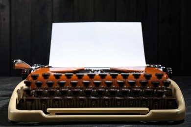 Photo of Vintage typewriter with sheet of paper on black background, closeup