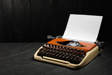 Photo of Vintage typewriter with sheet of paper on black background. Space for text