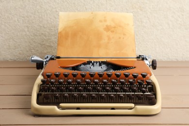 Photo of Vintage typewriter with parchment paper on wooden table