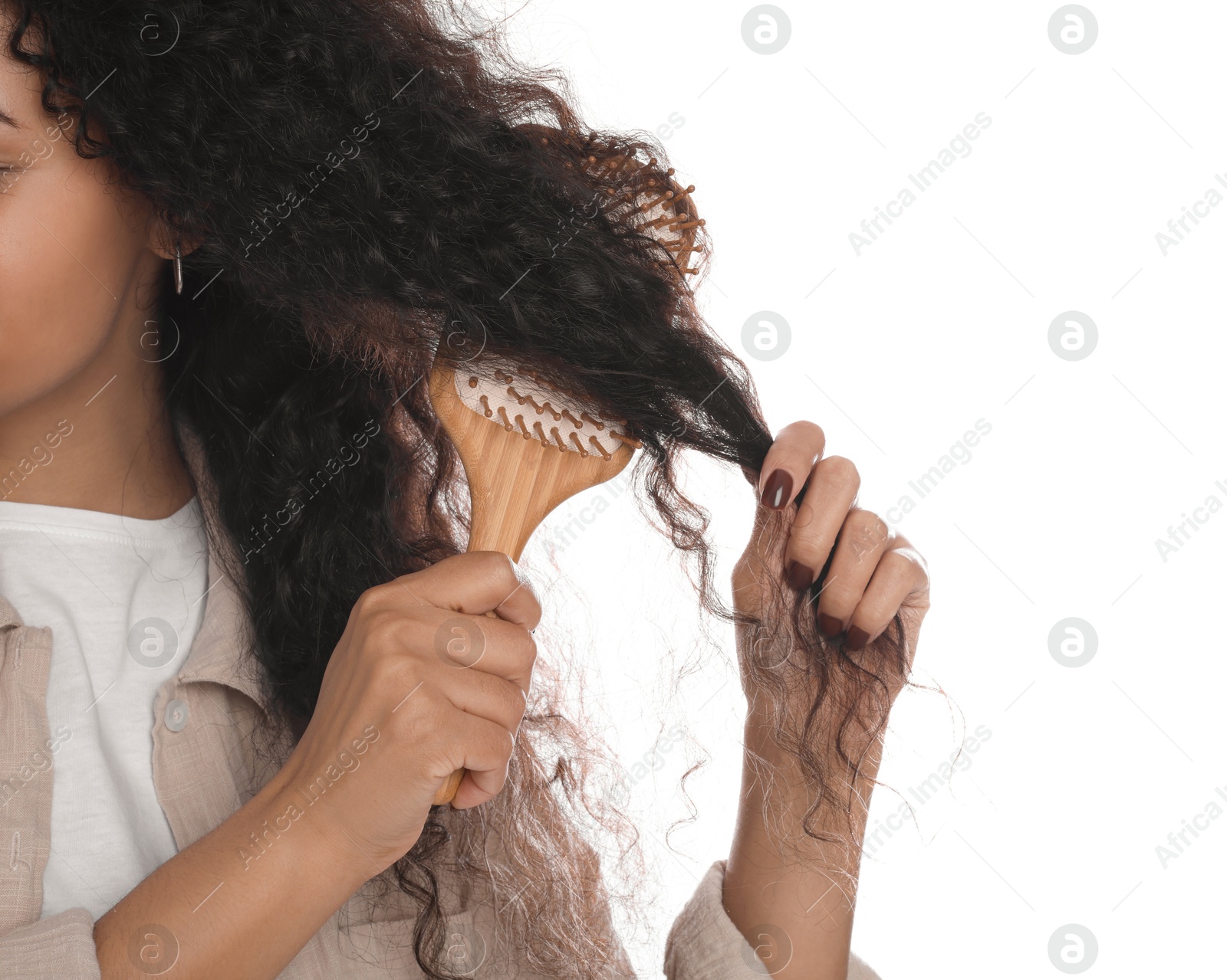 Photo of Woman brushing her curly hair on white background, closeup