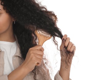 Photo of Woman brushing her curly hair on white background, closeup