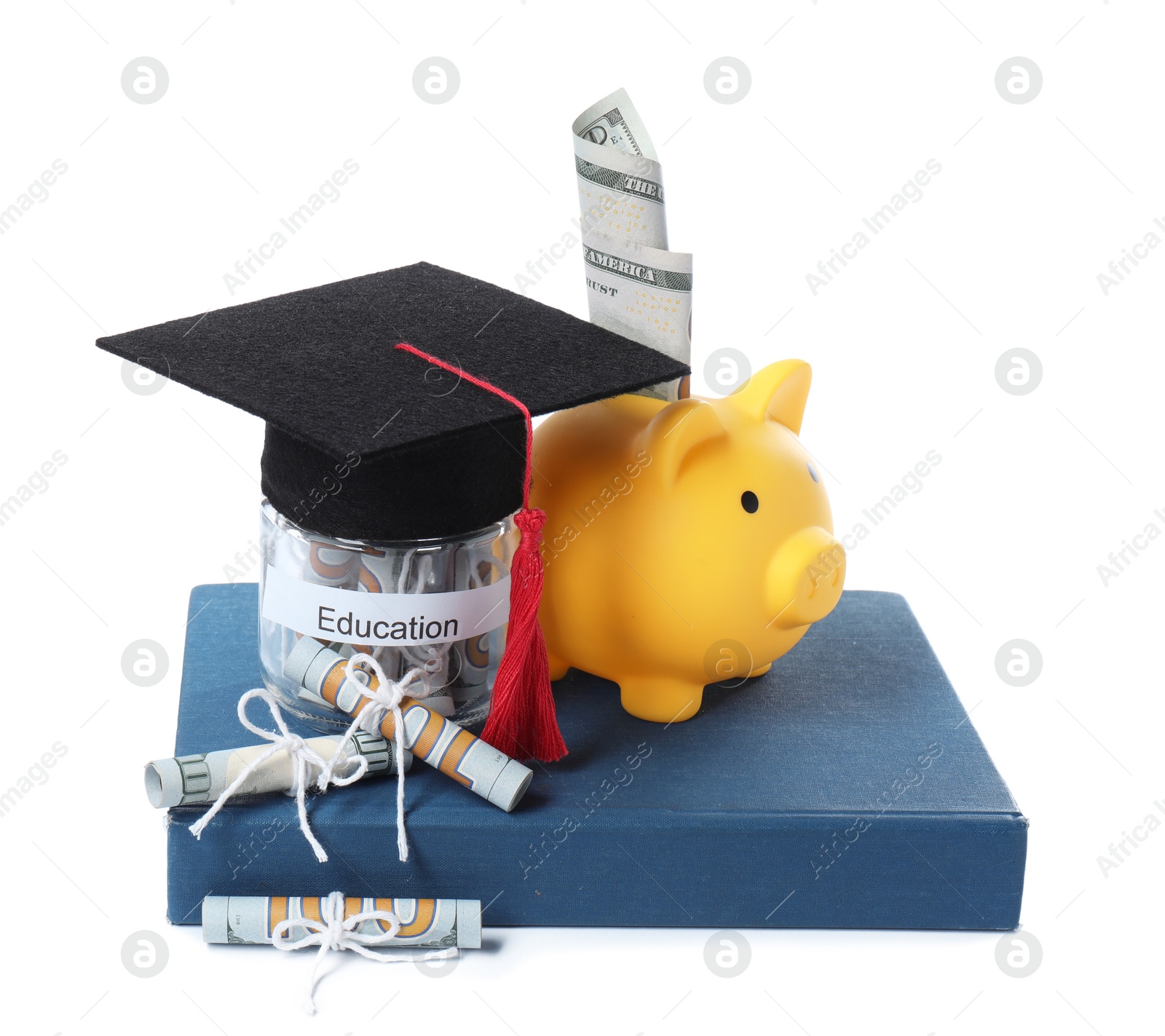 Photo of Piggy bank, graduate hat, dollar banknotes, book and glass jar with word Education isolated on white. Tuition payment