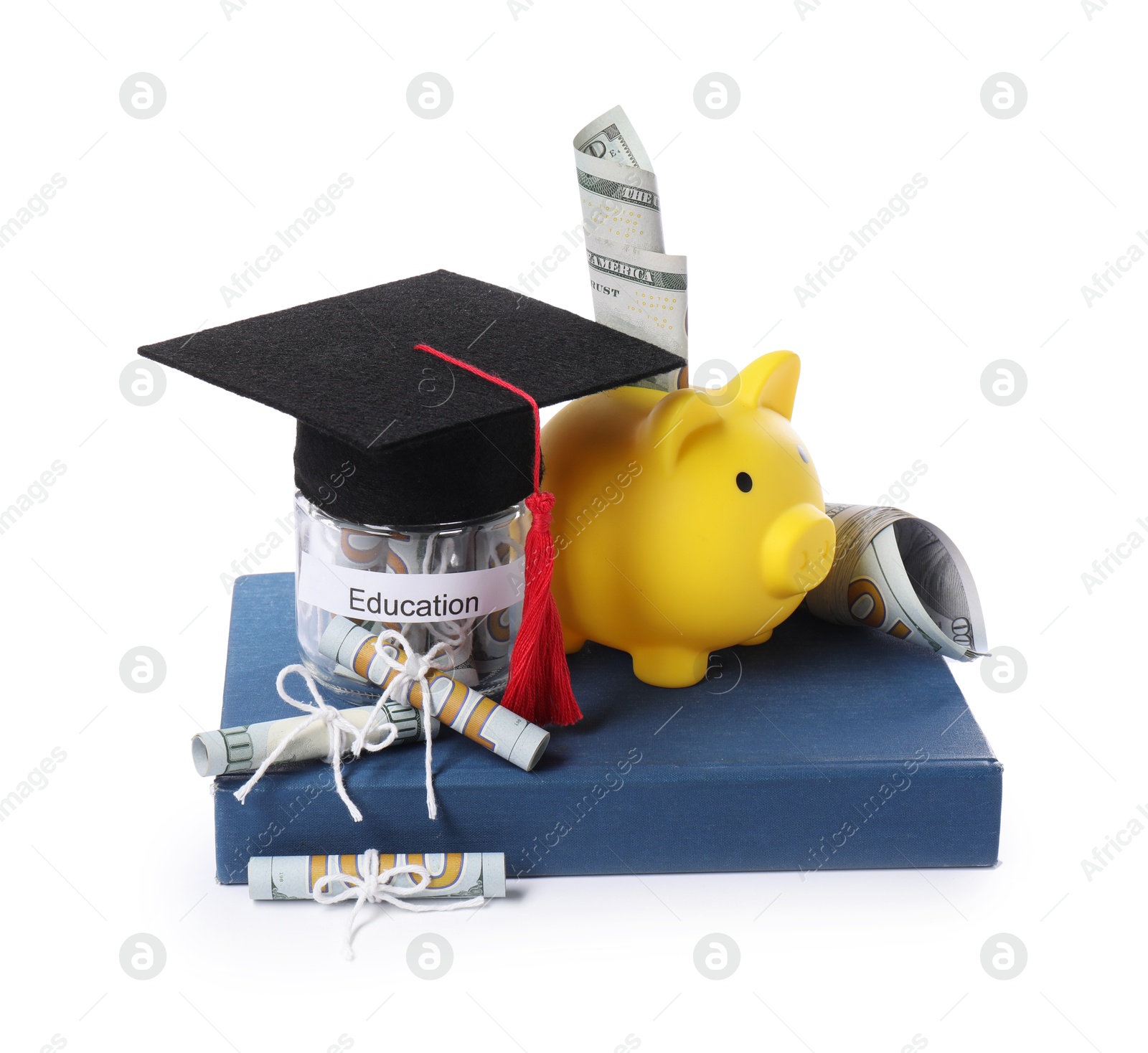 Photo of Piggy bank, graduate hat, dollar banknotes, book and glass jar with word Education isolated on white. Tuition payment