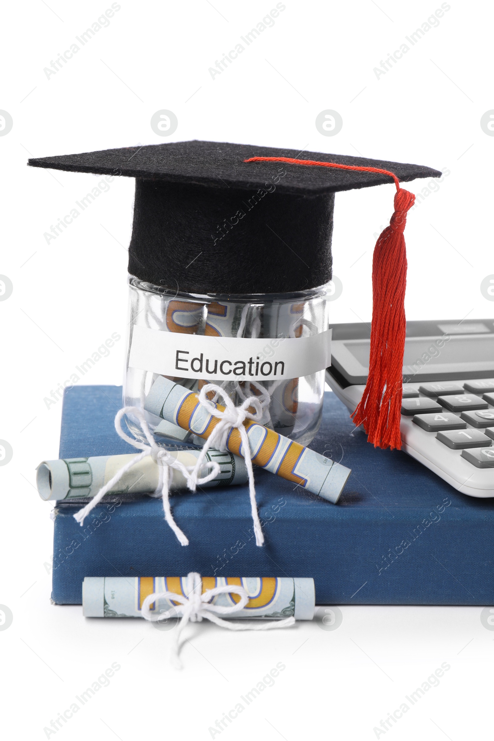 Photo of Graduate hat, dollar banknotes, calculator, book and glass jar with word Education isolated on white. Tuition payment