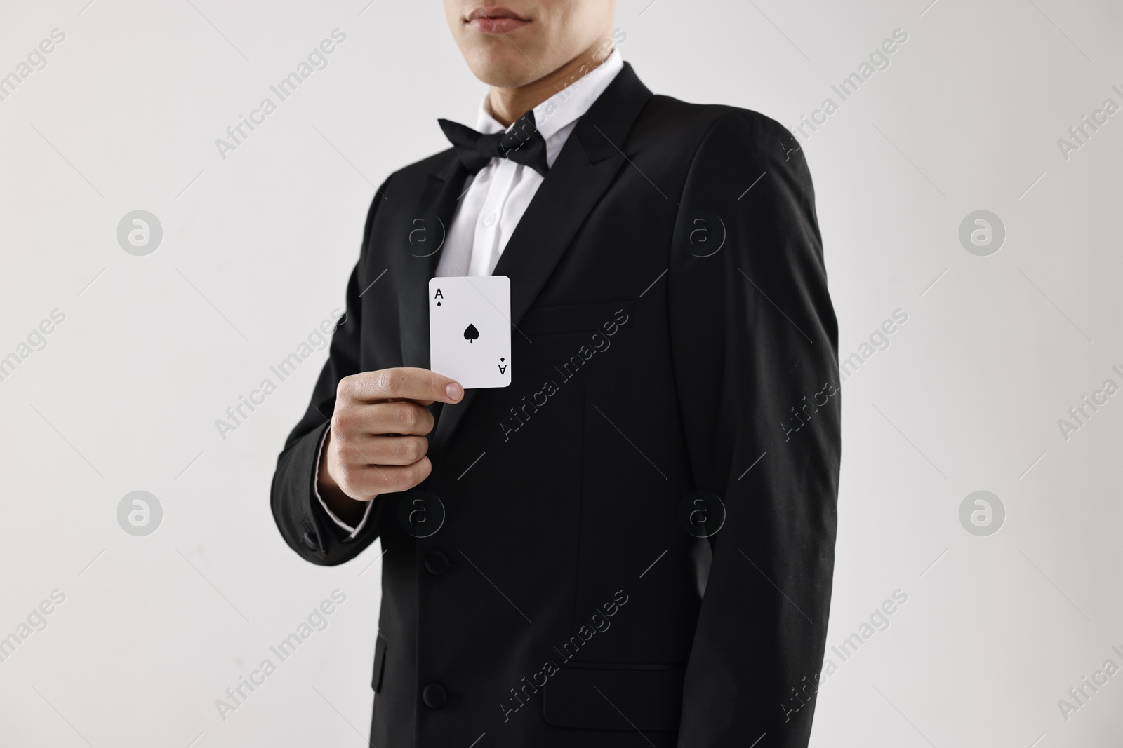 Photo of Illusionist showing playing card on white background, closeup