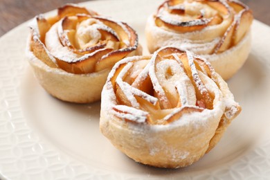 Photo of Freshly baked apple roses on plate, closeup
