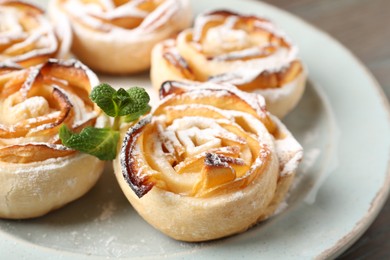 Photo of Freshly baked apple roses on table, closeup