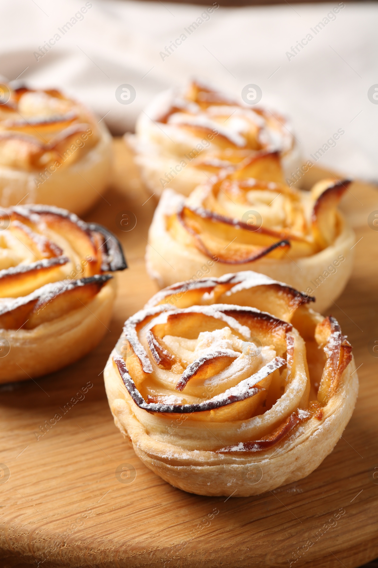 Freshly baked apple roses on wooden board, closeup Photo of Freshly baked apple roses on wooden board, closeup