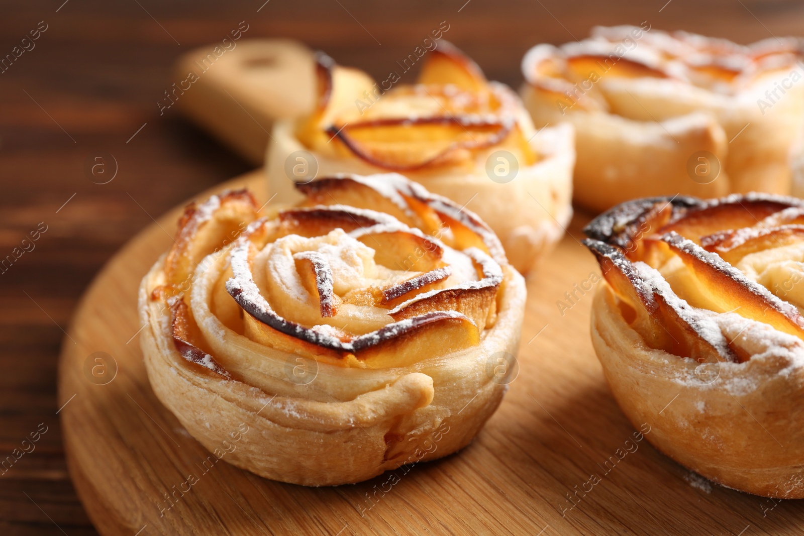 Photo of Freshly baked apple roses on table, closeup