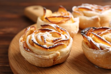 Photo of Freshly baked apple roses on table, closeup