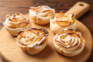 Photo of Freshly baked apple roses on table, closeup