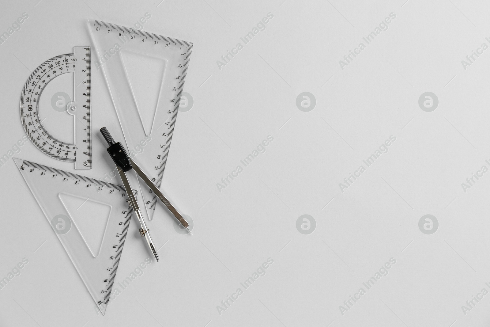 Photo of Rulers and compass on light grey background, flat lay. Space for text