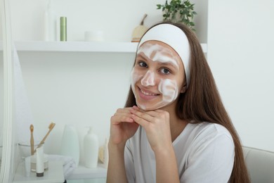 Photo of Teenage girl with cleansing foam on her face at home. Acne treatment