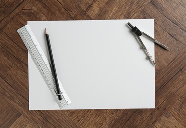 Photo of Ruler, paper, compass and pencil on wooden table, flat lay. Space for text