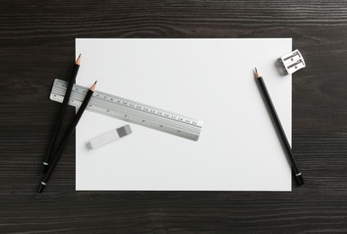 Photo of Ruler, paper and other stationery on black wooden table, flat lay. Space for text