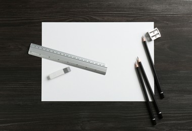 Photo of Ruler, paper and other stationery on black wooden table, flat lay. Space for text