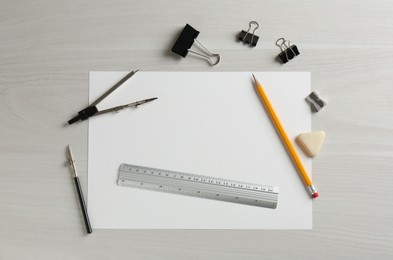 Photo of Ruler and other stationery on white wooden table, flat lay. Space for text